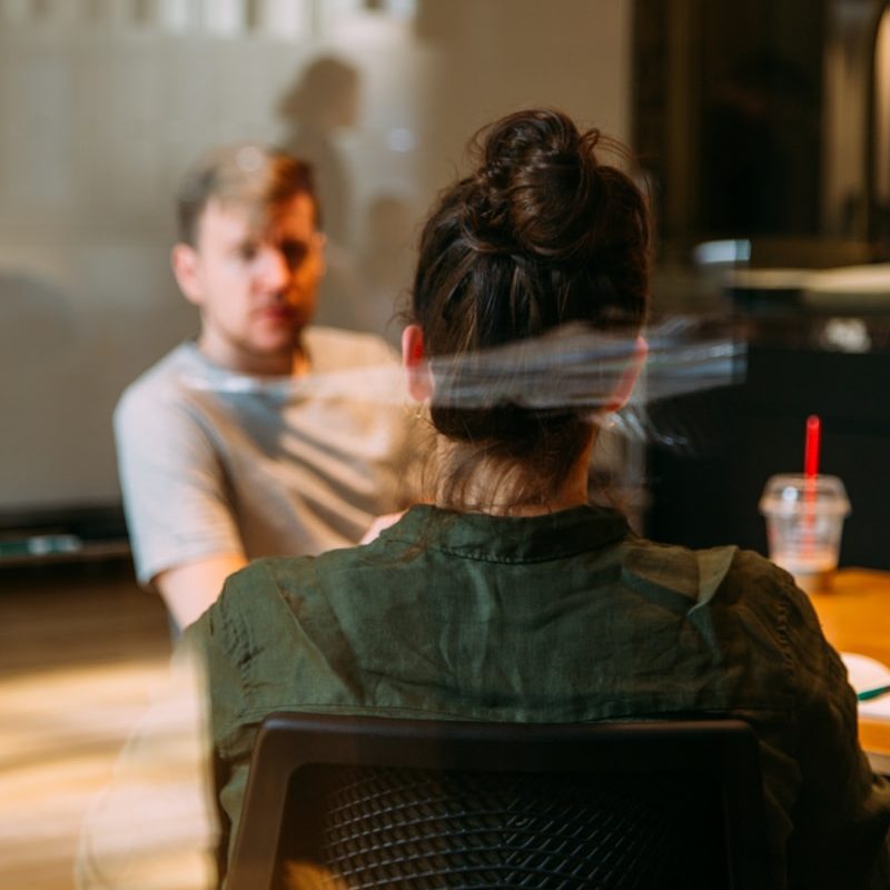 Photo by charlesdeluvio person sitting in a chair in front of a man